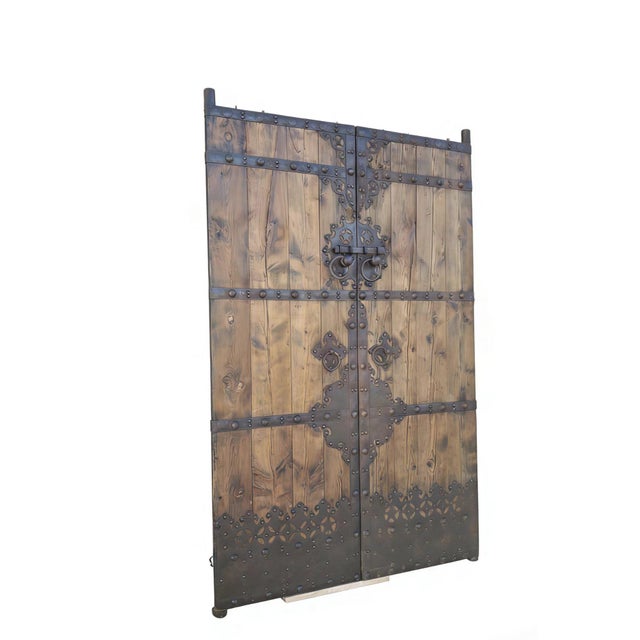 This pair of antique screen door panels showcase a striking blend of rustic wood and intricate, hand-forged ironwork....