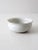 This is a vintage handmade studio pottery bowl. The white speckled glaze bowl has a subtle etched design around the base...