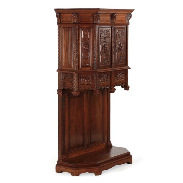GOTHIC REVIVAL CARVED WALNUT COURT CUPBOARD France c. 1880 Carved walnut, iron 64 3/8” H x 16 5/8” D x 38” W A handsomely...