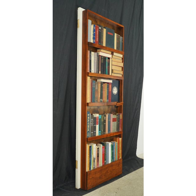 Reclaimed in swing hidden door with a four shelf half size bookcase on one side and a white painted two panel side on the...