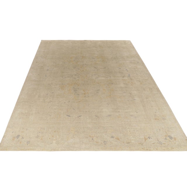 Hand knotted in quality wool, this 12x16 modern rug enjoys muted classic inspirations in tones of beige with gold and...