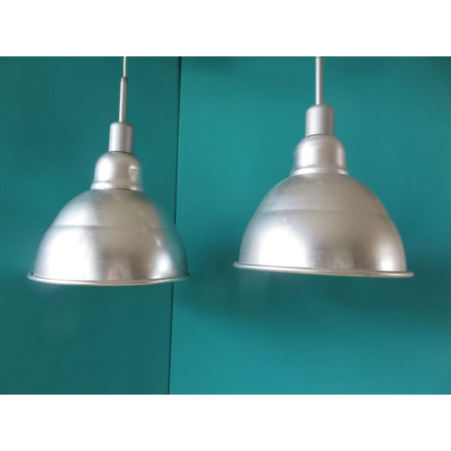 Set of two brushed aluminum pendant lights. They have been rewired and take maximum 75 Watts. European Plug (up to...
