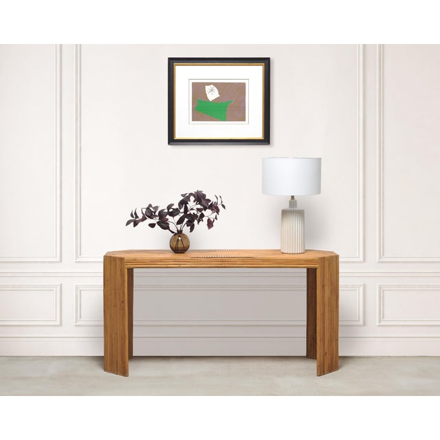 A striking 1970s midcentury pencil reed rattan console table, constructed in the Organic Modern and Tropical styles after...