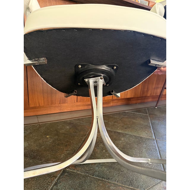Pair of 1970’s Mid century modern white chrome swivel chairs that have been reupholstered. The chairs are intact. There...