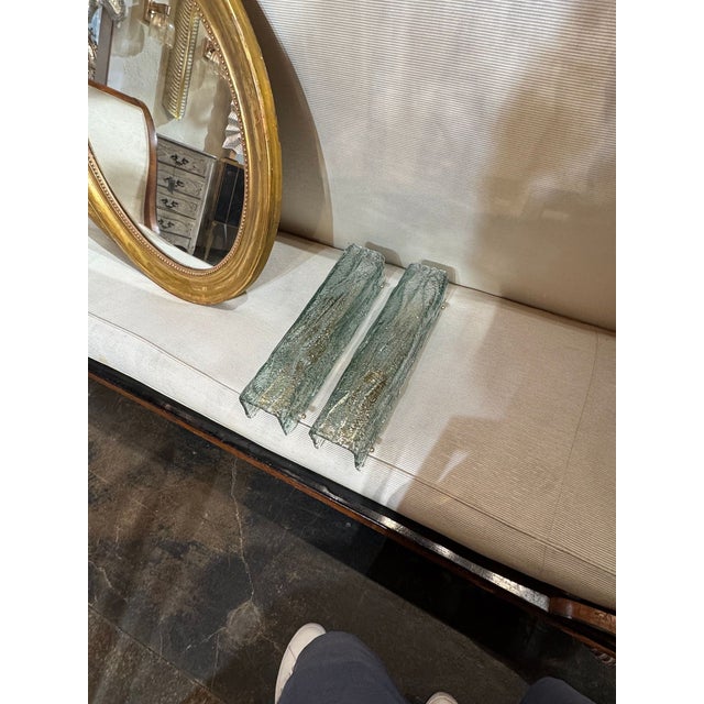 The product is a pair of Murano Fontana green granola glass square tube sconces. These sconces are elegant and unique,...