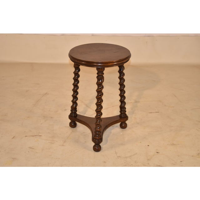19th century round oak stool from England. The top has lovely figuring and is surrounded by a molded band around the seat....