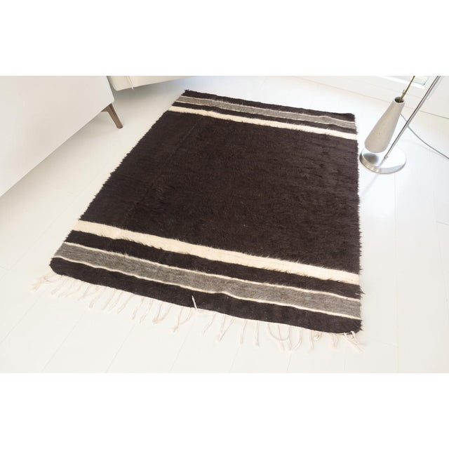 This is a vintage Turkish Oushak rug from the Mid 20th Century. The piece was hand-knotted.