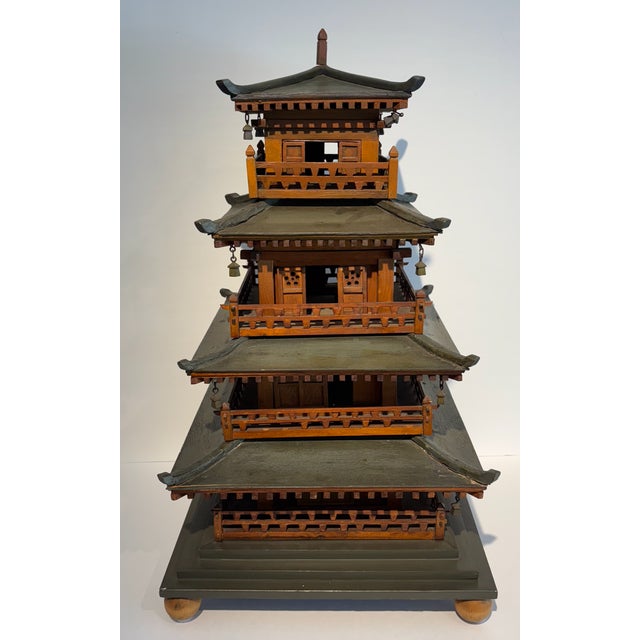 A fantastic large scale Chinese wooden model of a pagoda with four tiered flared eaves, sliding wood doors and tinkling...