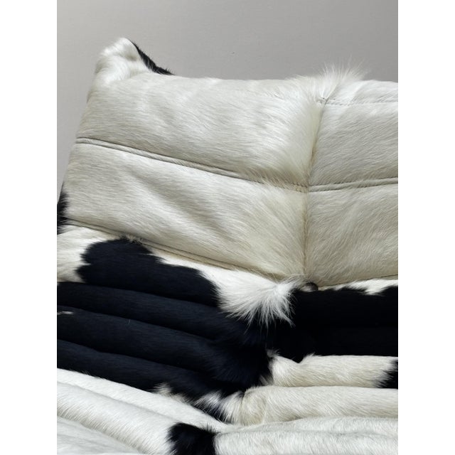 Togo armchair reupholstered in two-tone black and white cowhide. The original cover will be included. The hide has some...
