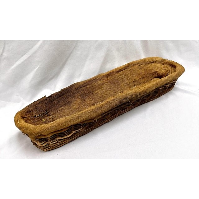 Imported from Belgium. Vintage French hand woven wicker bread basket lined with a burlap grain sack remnant. This grain...