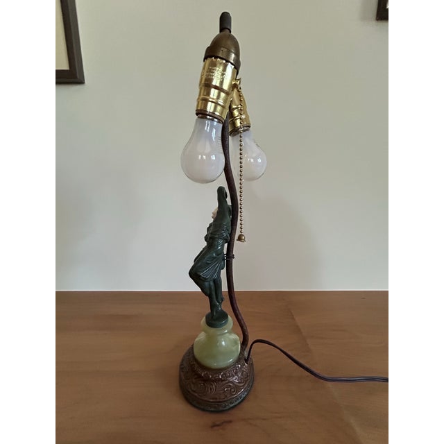 This lovely Art Deco period lamp from Austria featuring the patinated figures of male and female harlequins embraced in a...