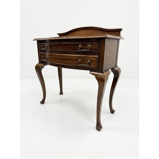 A charming early 20th century bow-fronted side table, featuring a shaped top with a raised gallery back. The piece is...