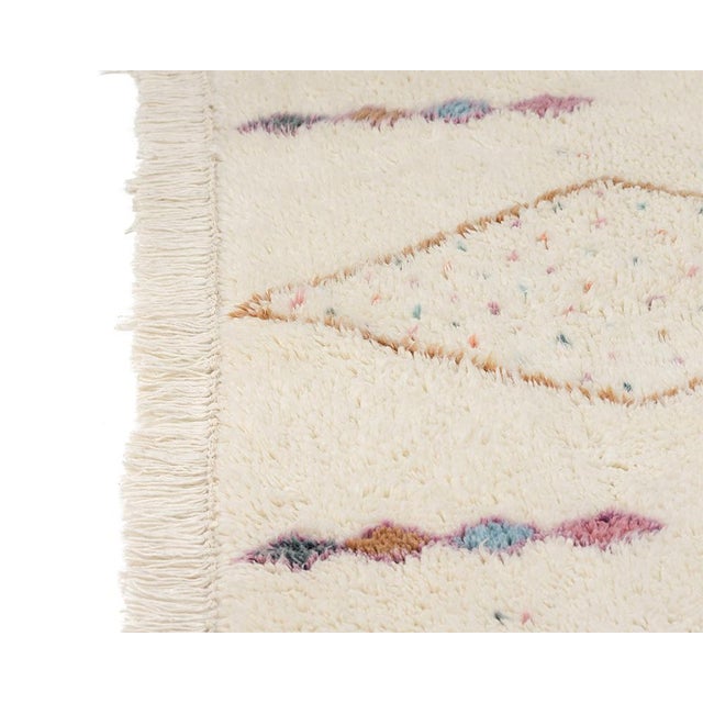 Delicate tribal symbols scatter across an ivory field like a hand-drawn constellation, each tiny motif rendered in a soft,...