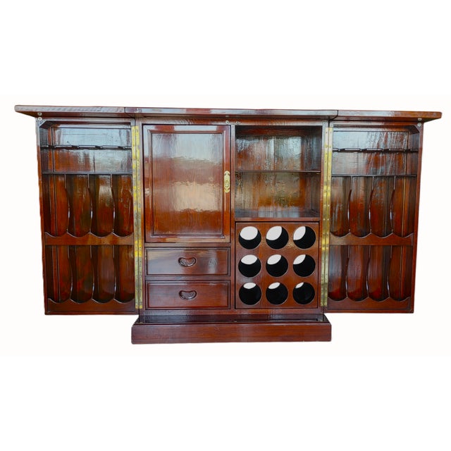 Impressive vintage Chinese hand carved bar cabinet features heavily carved garden scenes and figurals on 4-sides including...