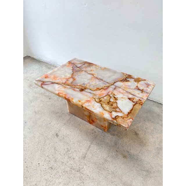 This Pink Onyx Coffee Table is a luminous showpiece, crafted from subtly transparent stone that catches and reflects...