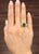This exquisite ring showcases a 2.83-carat emerald-cut emerald, radiating a vibrant green hue. Flanked by marquise-cut...
