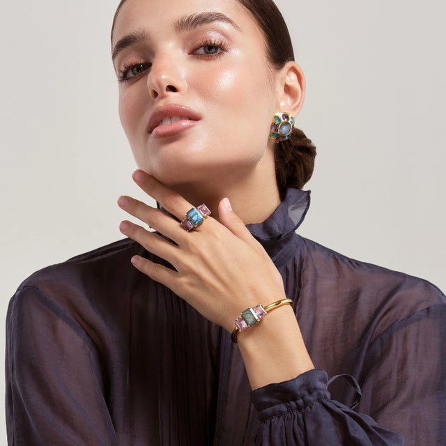 The Annette Ring showcases a classic design, with a trio of emerald-cut multi-colored stones meticulously set to create a...