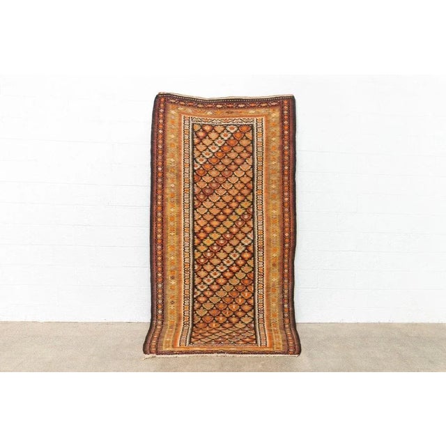 This elegant antique Persian Veramin kilim rug circa early to mid 1900s is expertly hand-knotted from all-natural,...