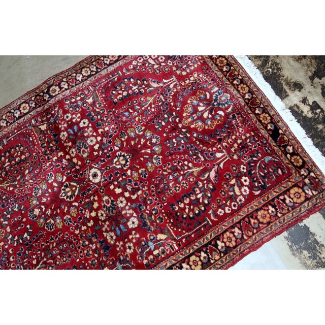 Handmade antique Sarouk rug in bright red colour. The rug is in original good condition from the beginning of 20th...