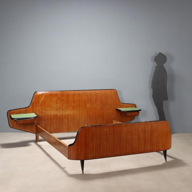 Double bed with wall-mounted bedside tables with drawers. It features an exotic wood veneer with a polyester finish. The...