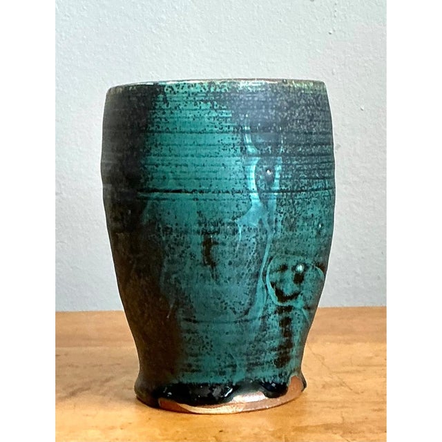 This vase presents a substantial, barrel-like silhouette, its cylindrical body curving gently outward at the midsection...