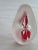 An art glass paperweight, oval shaped, with a red design inside. Size: 4" tall and 7.5" diameter at the widest point in...