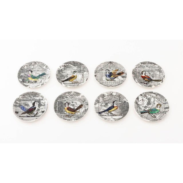 Set of Eight Piero Fornasetti "Le Arpie Gentili" Porcelain Coasters, depicting caged harpy with hand-colored...