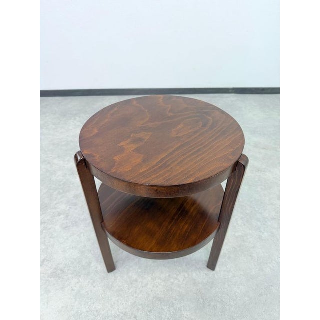 Elevate your space with this exquisite Art Deco / Functionalist round side table with an integrated lower shelf,...