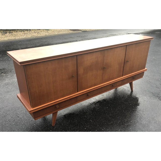 Rare teak sideboard with compass feet, creation by Gaston Poisson, from the 1960s Large storage capacity with shelves...