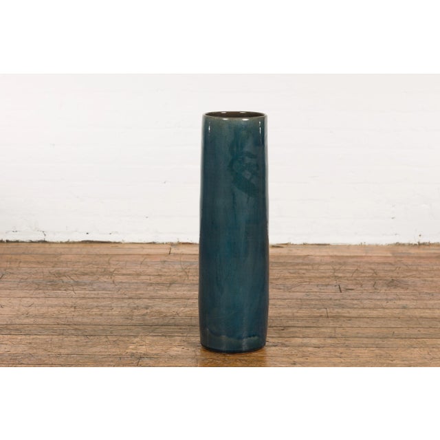 A Prem Collection ceramic handcrafted artisan floor vase with blue textured finish. Showcasing sleek lines and a blue...