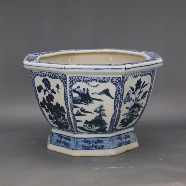 This elegant porcelain planter features an octagonal form with a flared rim, resting upon a matching pedestal base. The...