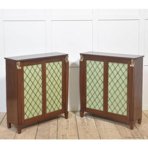 A refined and decorative pair of mahogany cabinets, executed in the Regency manner, distinguished by their elegant...