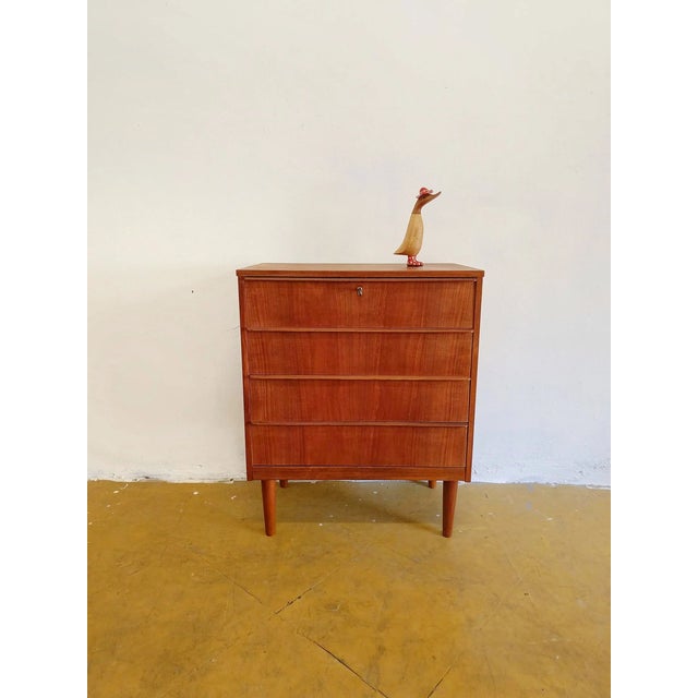 Vintage Danish teak chest of drawers from the 1950s with four drawers and integrated handles, featuring an elegant...