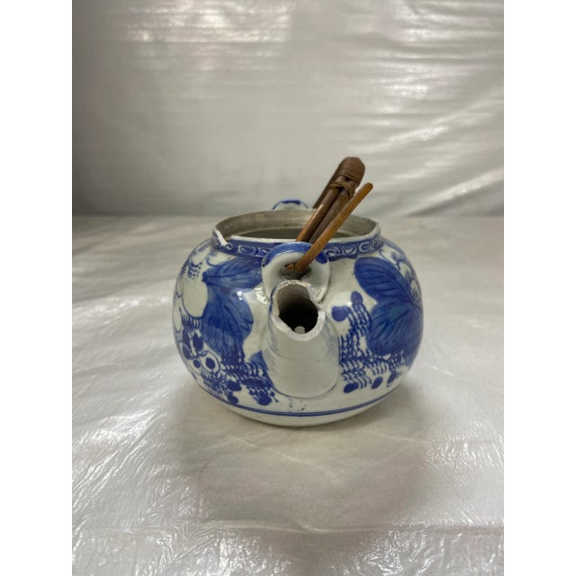 Antique blue and white Chinese porcelain tea pot with woven handle.