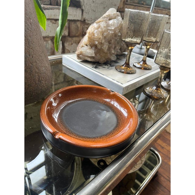 This 1970s Raymor Italian ceramic ashtray reflects mid-century modern design with its minimalist aesthetic. The piece...