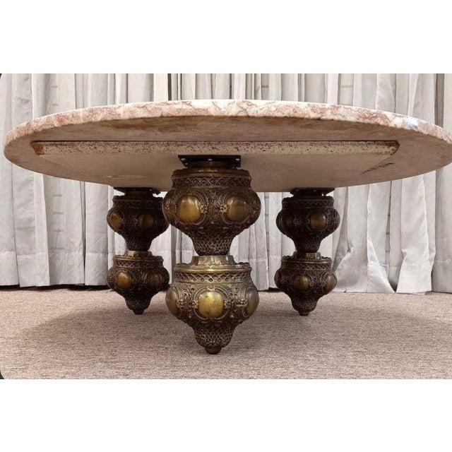 A unique Mid Century round rose Italian marble topped coffee table with ornate cast brass legs. This piece has that “it”...