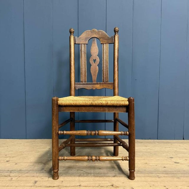 Dutch oak chair with rush seat, circa 1900. The oak is beautifully decorated in the backrest with lines and the shape of a...