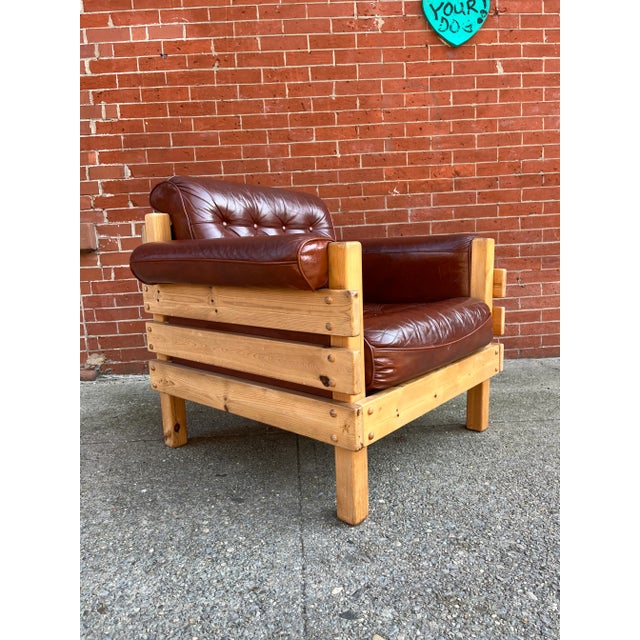 A sculptural pair of lounge chairs in solid pine, upholstered in a colorful vintage fabric. Attributed to Swedish Designer...