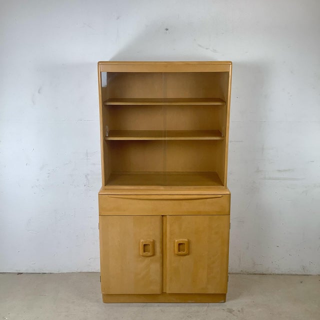 An exceptional example of American mid-century organic modernism, this two-piece china cabinet and hutch from Heywood-...