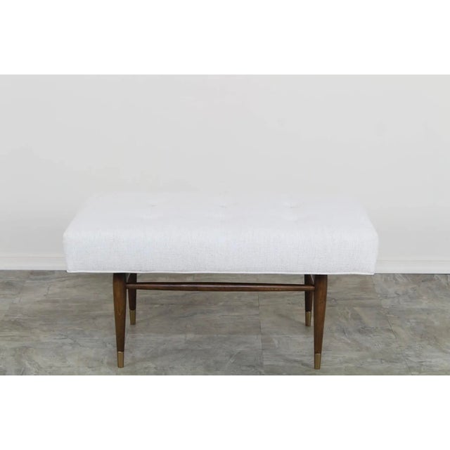 This is solid built walnut ottoman with chenille upholstered top. The base features slender tapered legs and a refined...