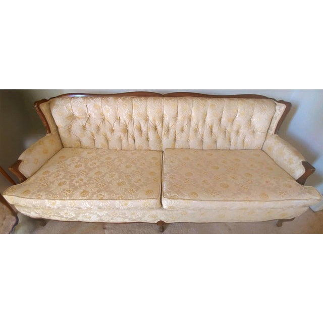A beautiful cream colored French Provincial sofa with gold floral print and carved wood trim. The sofa is in mint...