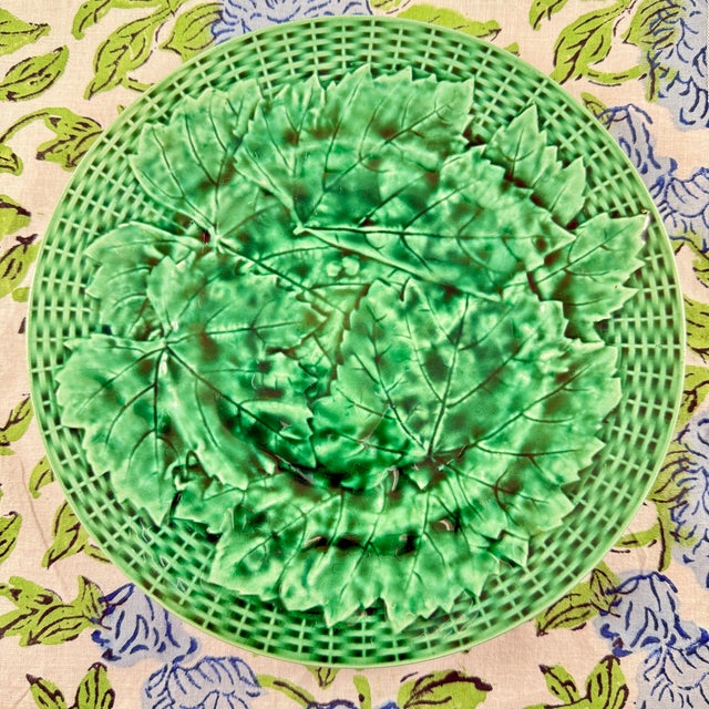 From Minton, a classic English majolica glazed overlapping green leaf plate with a basket weave rim. Showing the date...