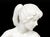 An elegant vintage German porcelain figurine depicting a seated nude female figure in a graceful twisting pose. Rendered...