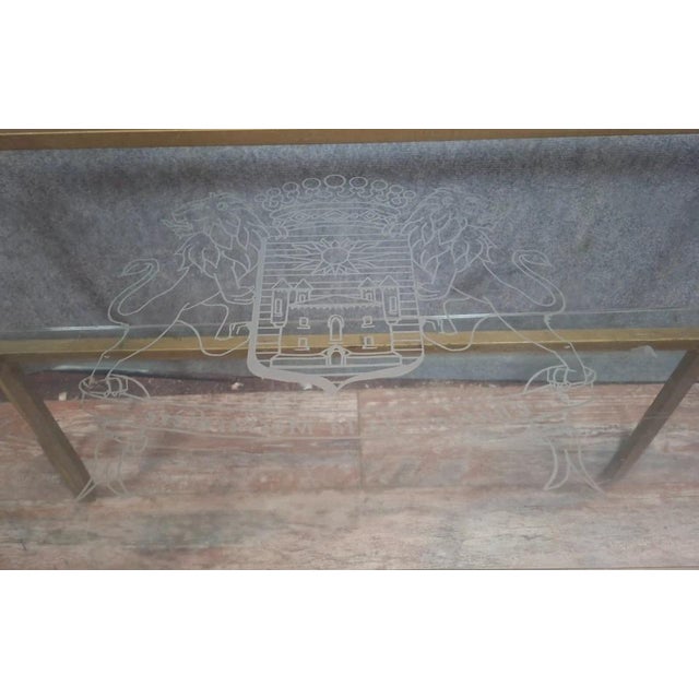 Brass and engraved glass coffee table, in the style of Maison Jansen, circa 1970. An elegant coffee table with a gilt...