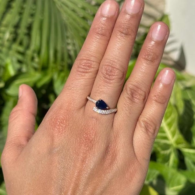 This statement ring showcases a 1.12 carat pear-cut blue sapphire set in 14k yellow gold. The sapphire measuring...