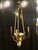A three-arm gilt bronze pendant light in the form of a conical bowl. The blown glass shade, decorated with floral motifs...