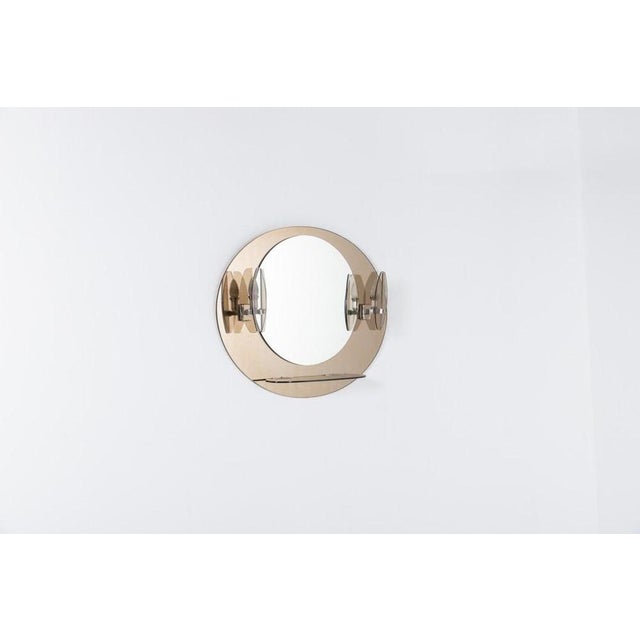 Mid-Century Italian Modern beveled mirror mounted onto smoked glass background, equipped with sconces and a smoked glass...