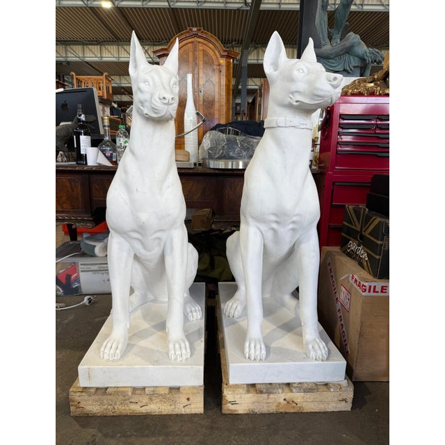 Striking in scale and execution, this pair of monumental hand-carved marble Doberman statues embodies strength, elegance,...