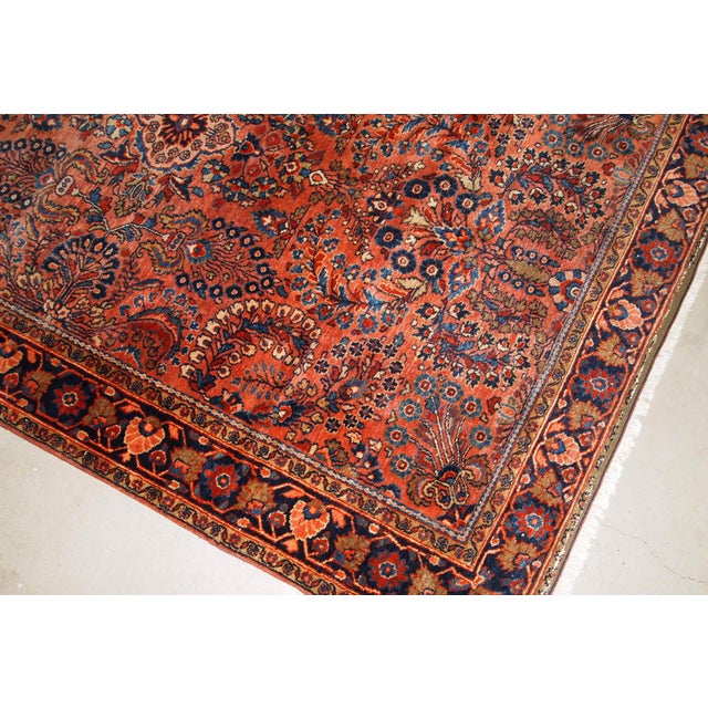 Handmade antique Sarouk rug in original good condition. The rug has been made in the beginning of 20th century in red...