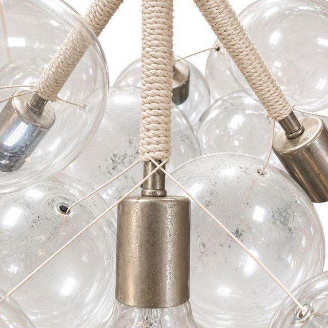 The Pelle Large Bubble Chandelier is a sculptural statement light defined by a dramatic cluster of oversized clear glass...